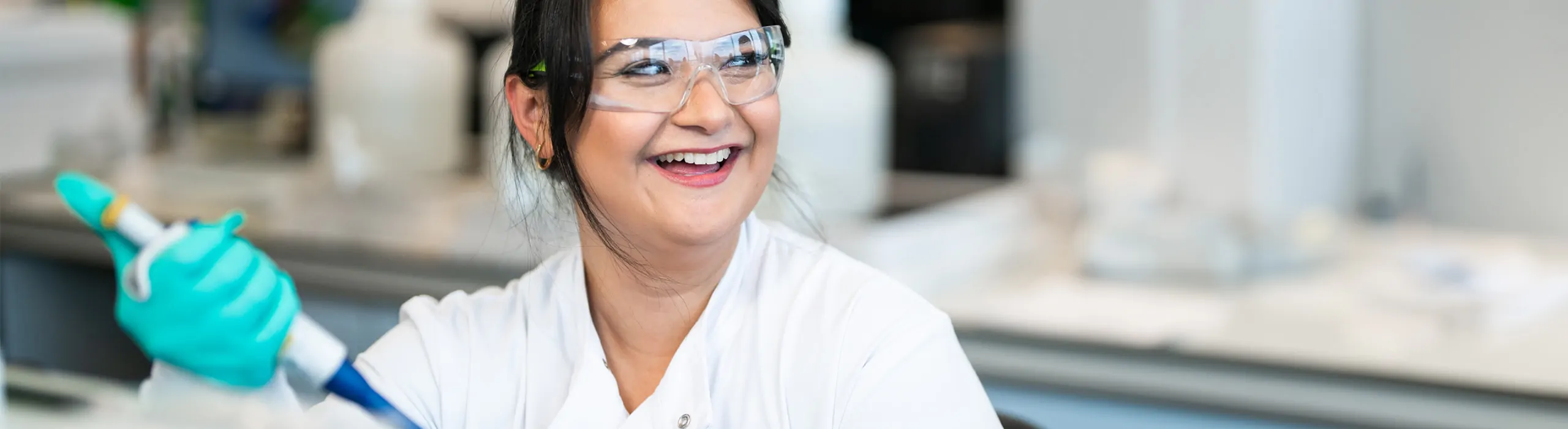 woman smiling while using micropipette