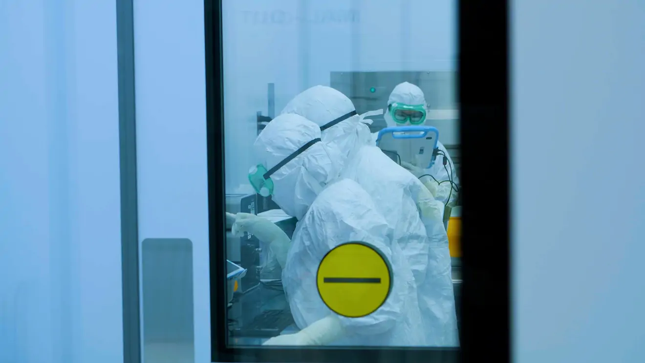 gowned technicians working in the lab